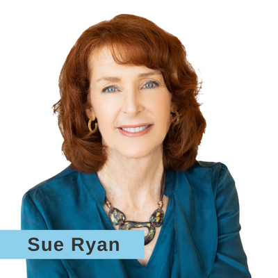 Sue Ryan smiling in a teal suit