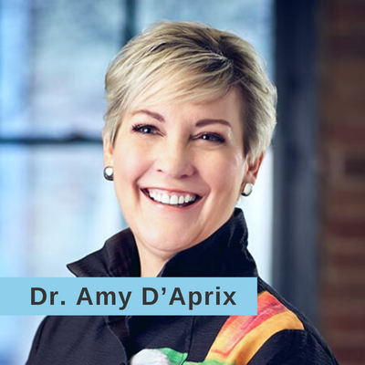 Dr. Amy D'Aprix smiling in a black jacket with a gold and red stripe on one sleeve